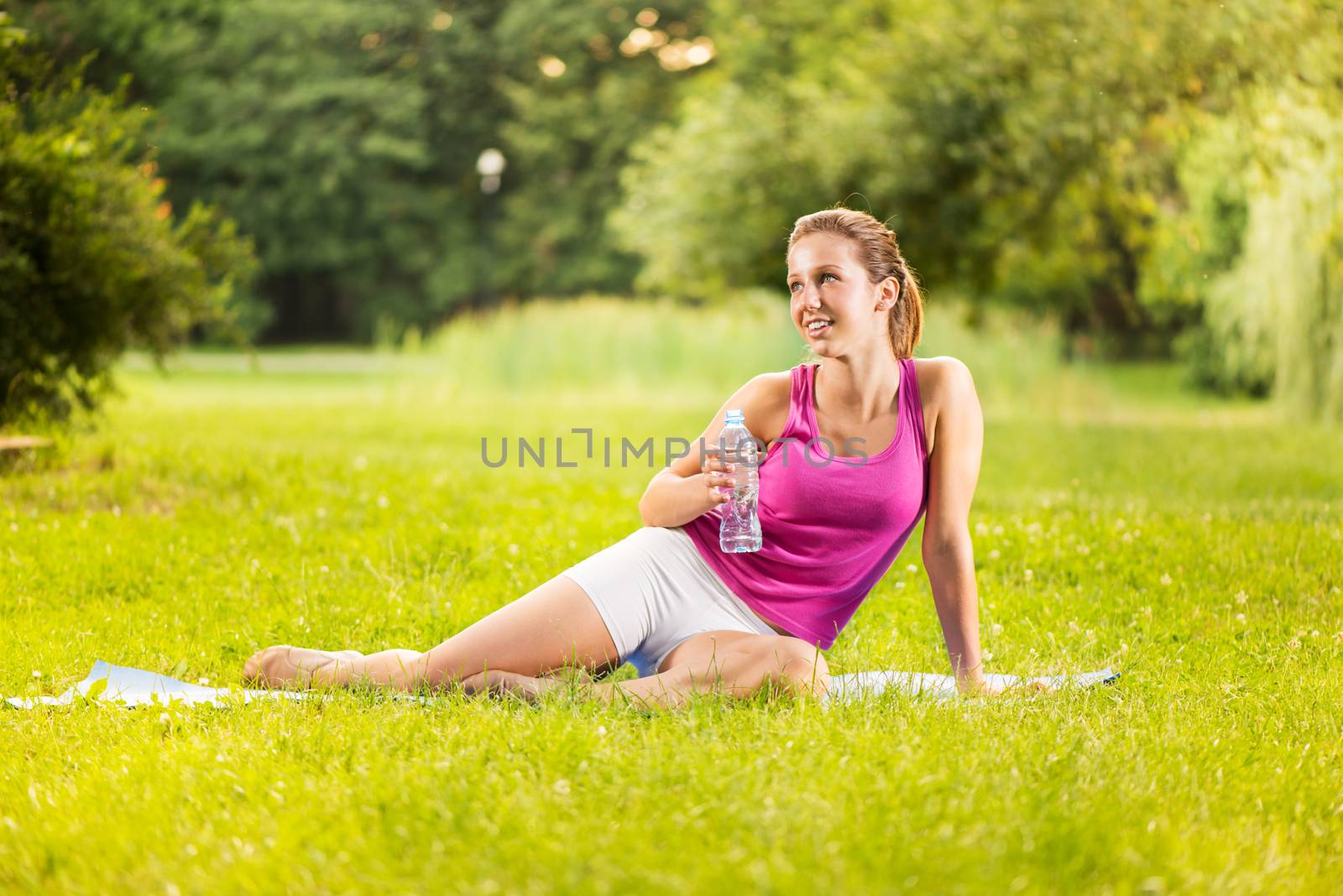 Beautiful young woman resting after exercising in the park.