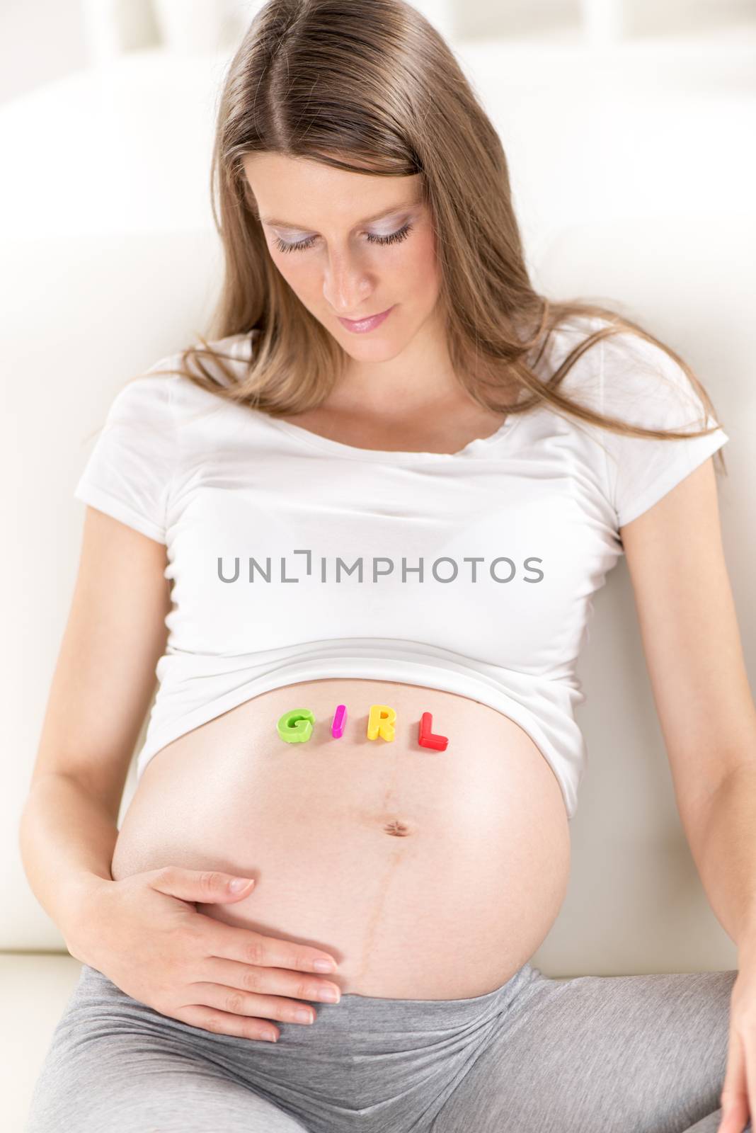 Multi Colored letters spelling Girl on a pregnant belly.