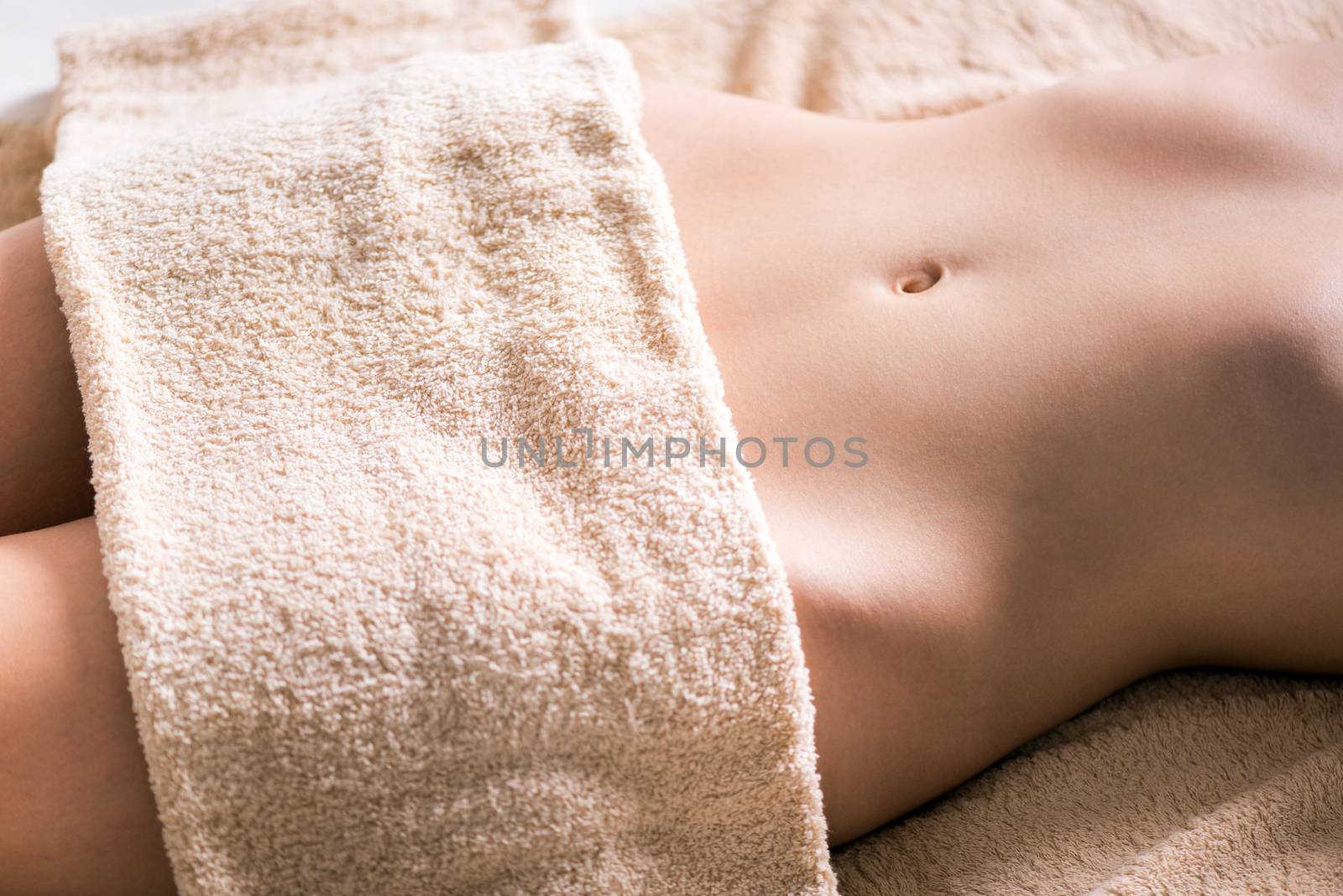 Beautiful female body covered with a towel.
