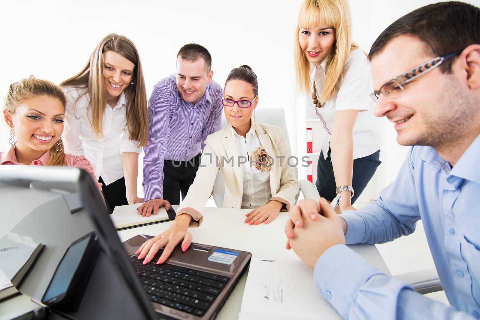 Successful young Business woman showing her colleagues project at laptop in the office.