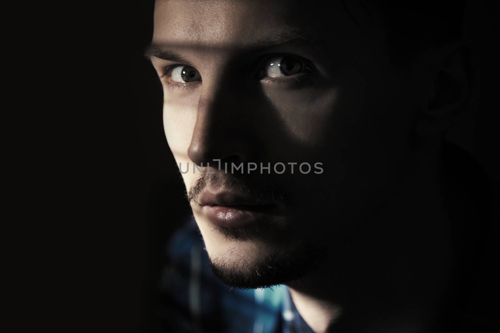 Illegal man in the dark prison. Close-up portrait