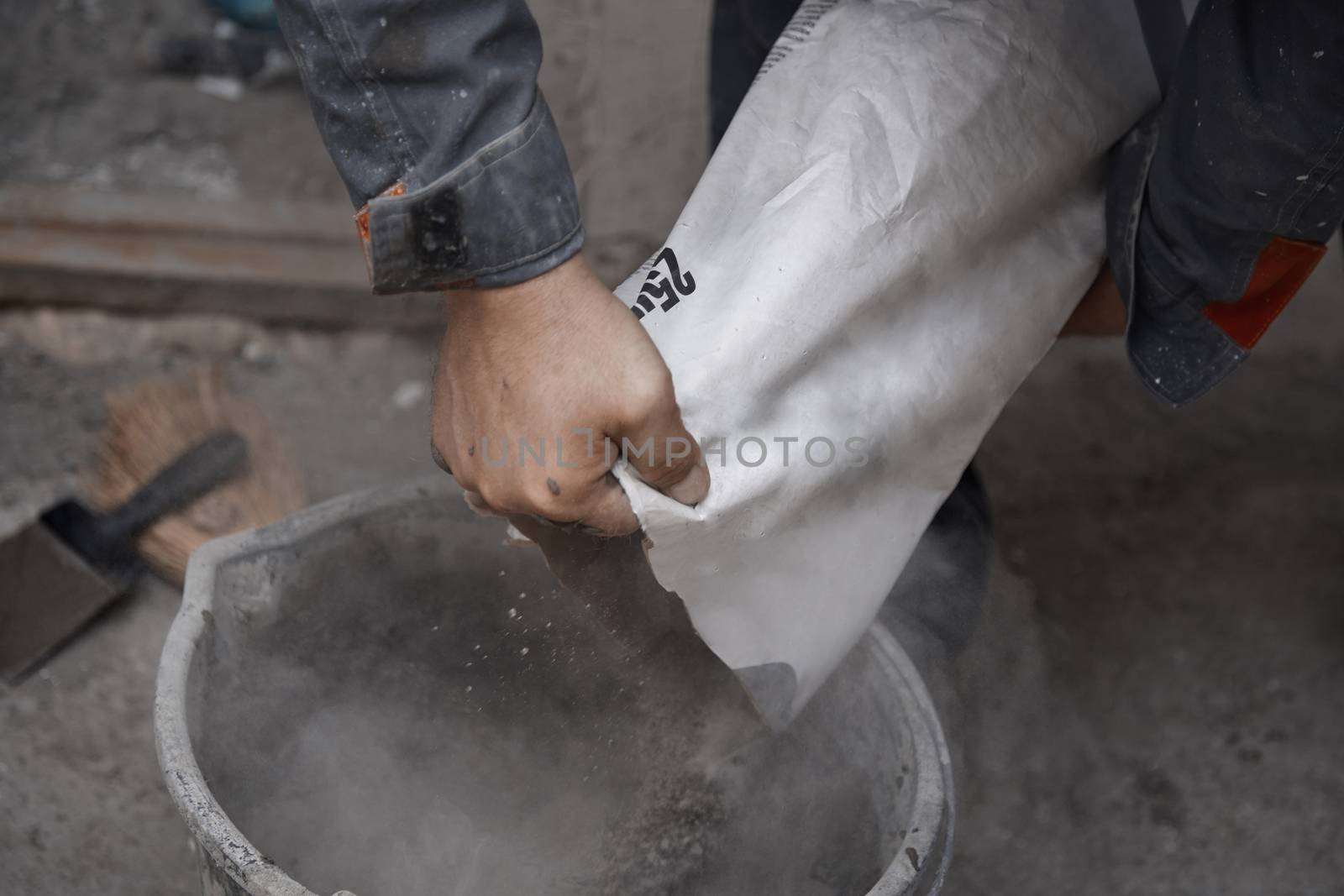 Construction worker pouring the cement to the bucket