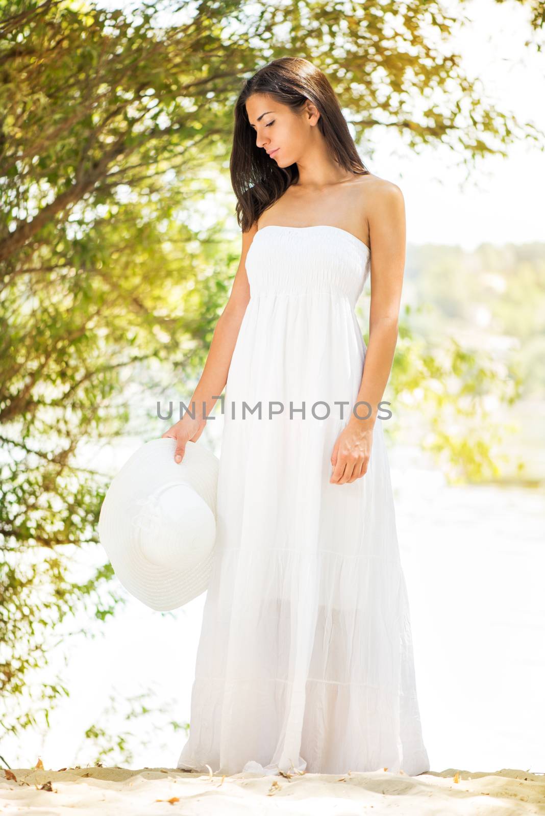 Young beautiful woman in white dress relaxing in the nature.