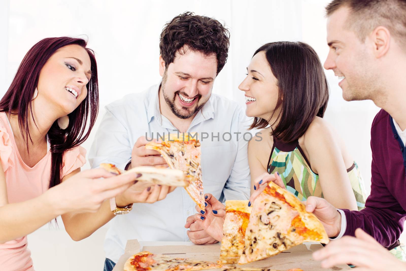 Group of happy friends sitting and eating pizza at Home Interior.