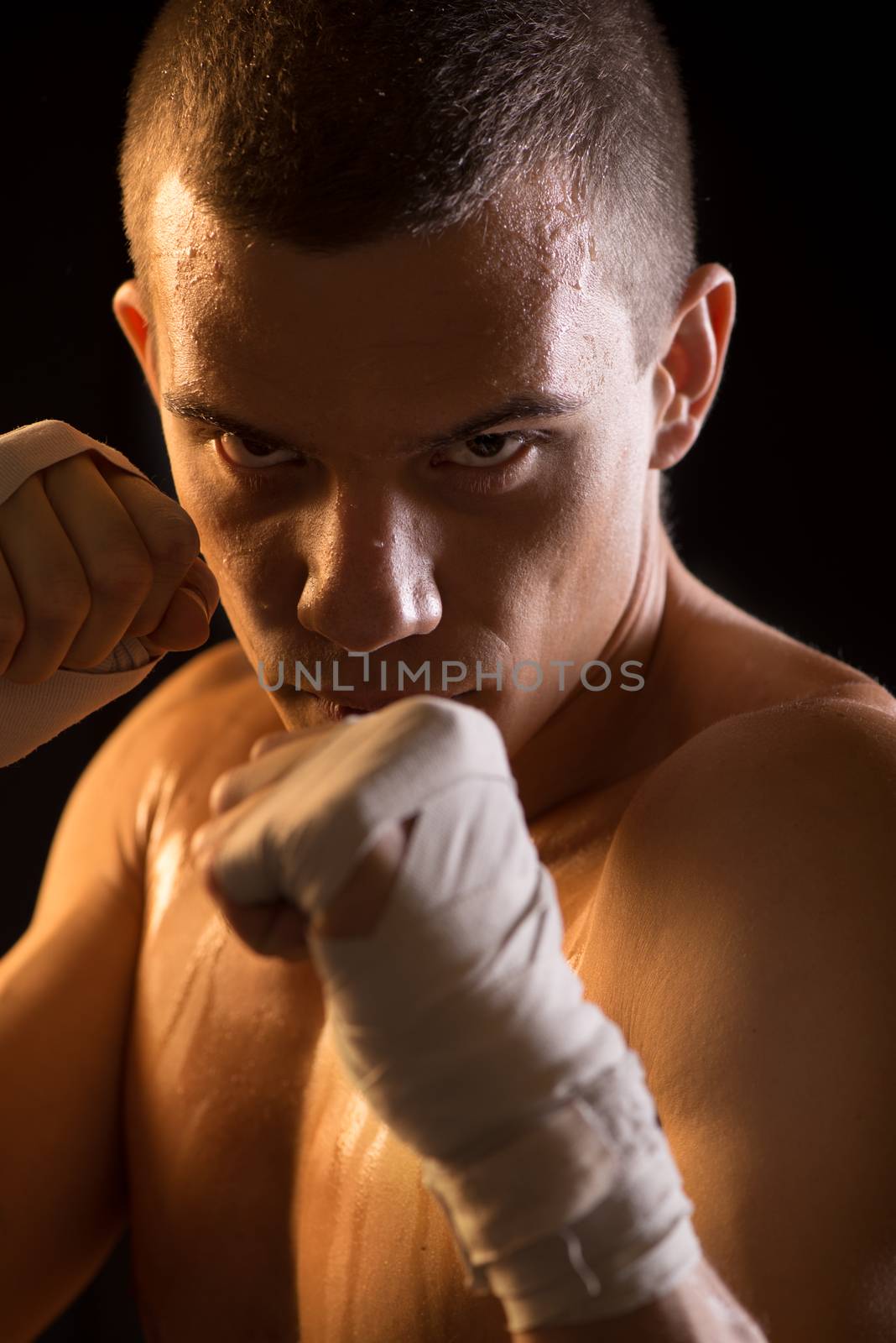 Portrait of a young Fighter on black background.