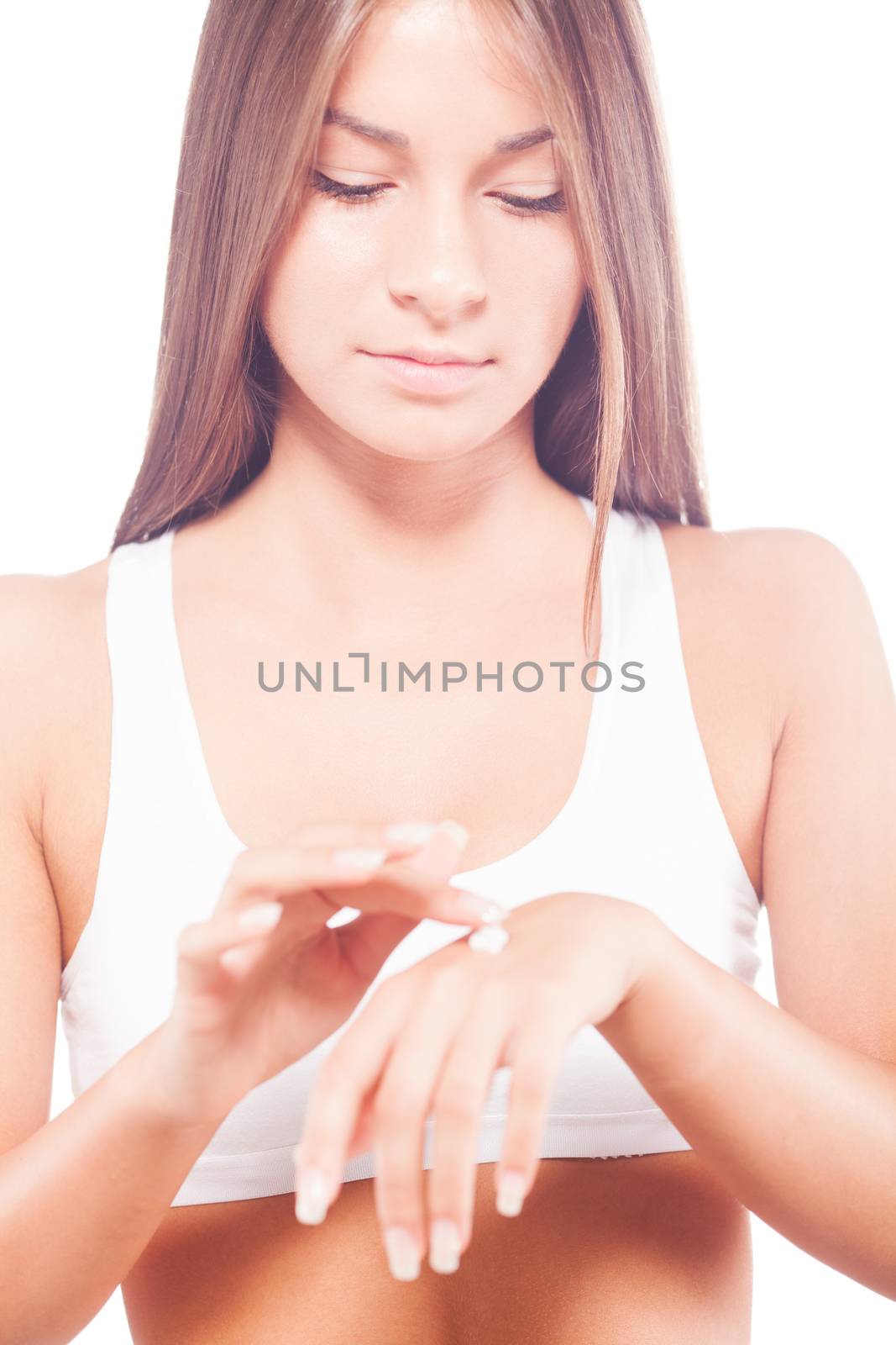 Beautiful young woman applying hand lotion.