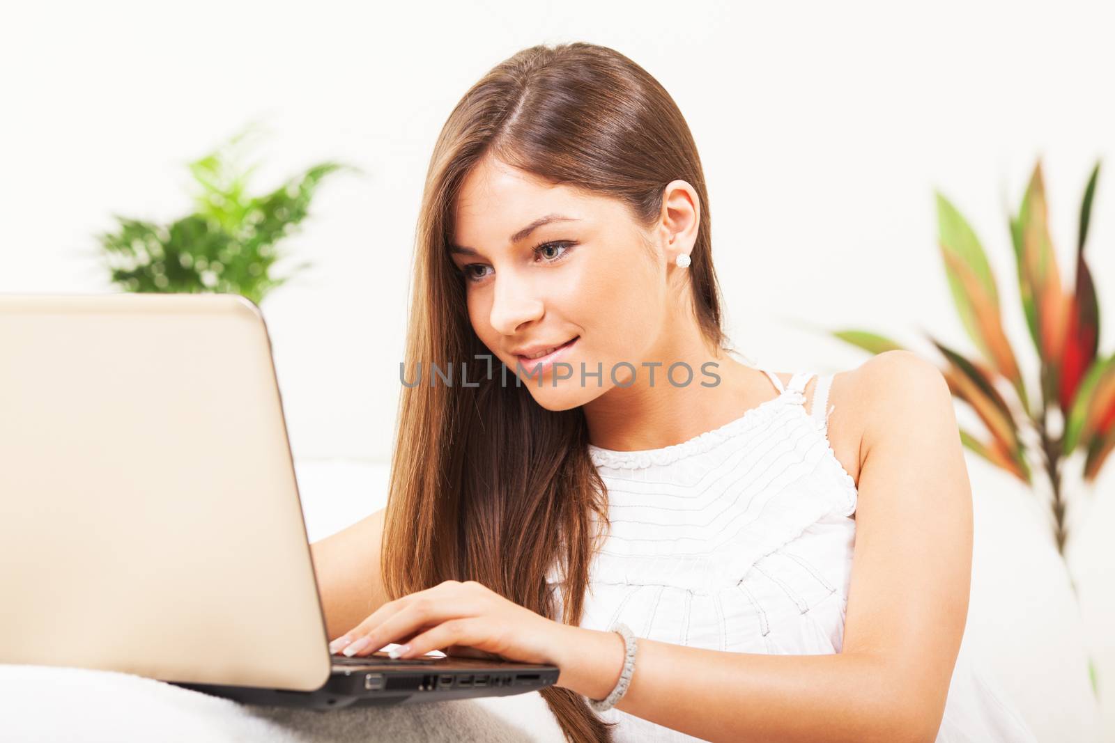 Beautiful Teenage girl  sitting in living room and using laptop.