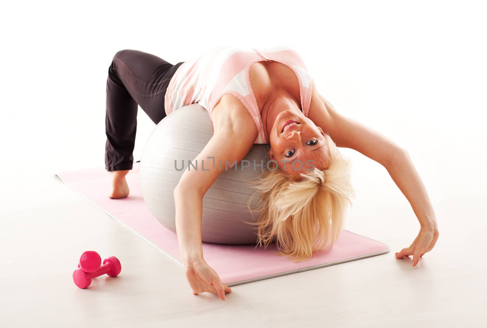 Beautiful mature woman stretching after pilates training.