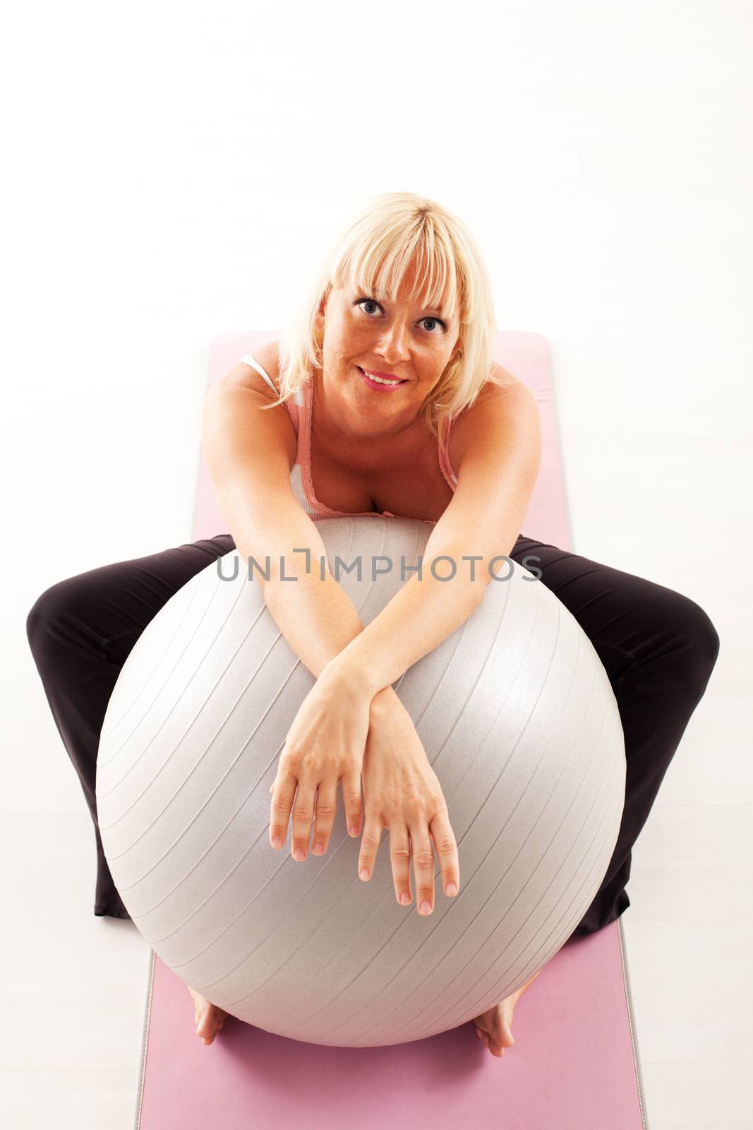 Beautiful mature woman relaxing after pilates training.