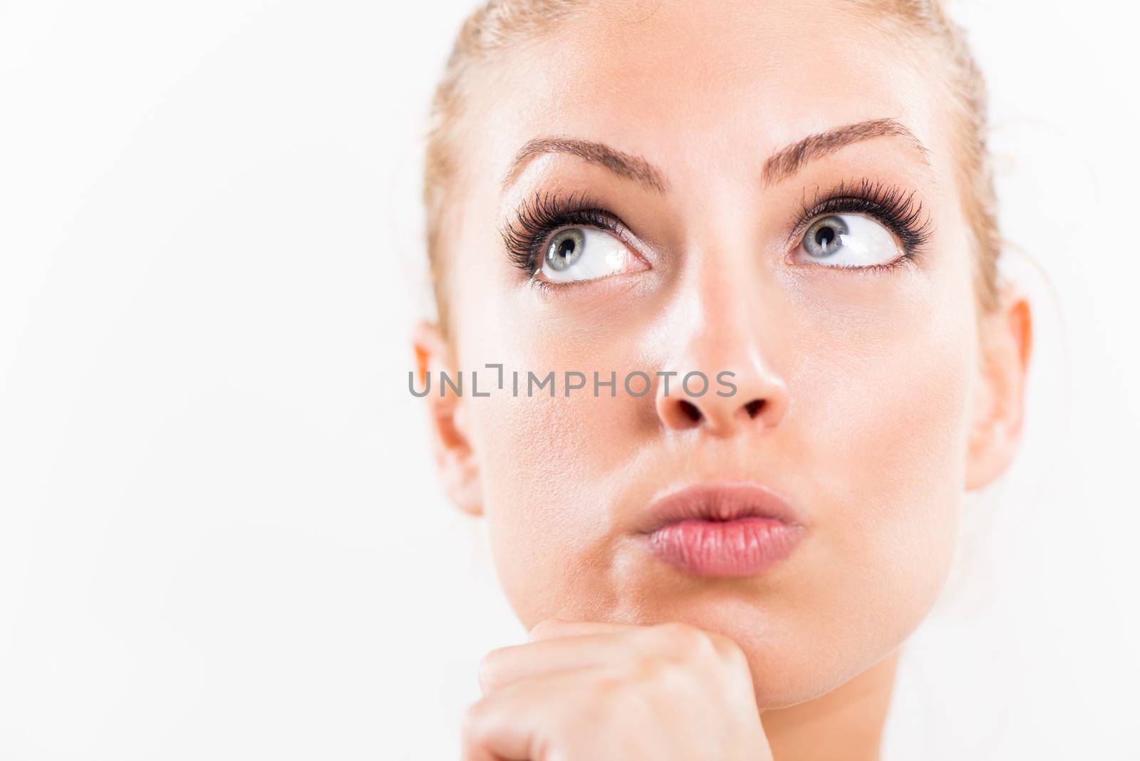 Portrait of beautiful young woman thinking and looking up. Close-up with white background.