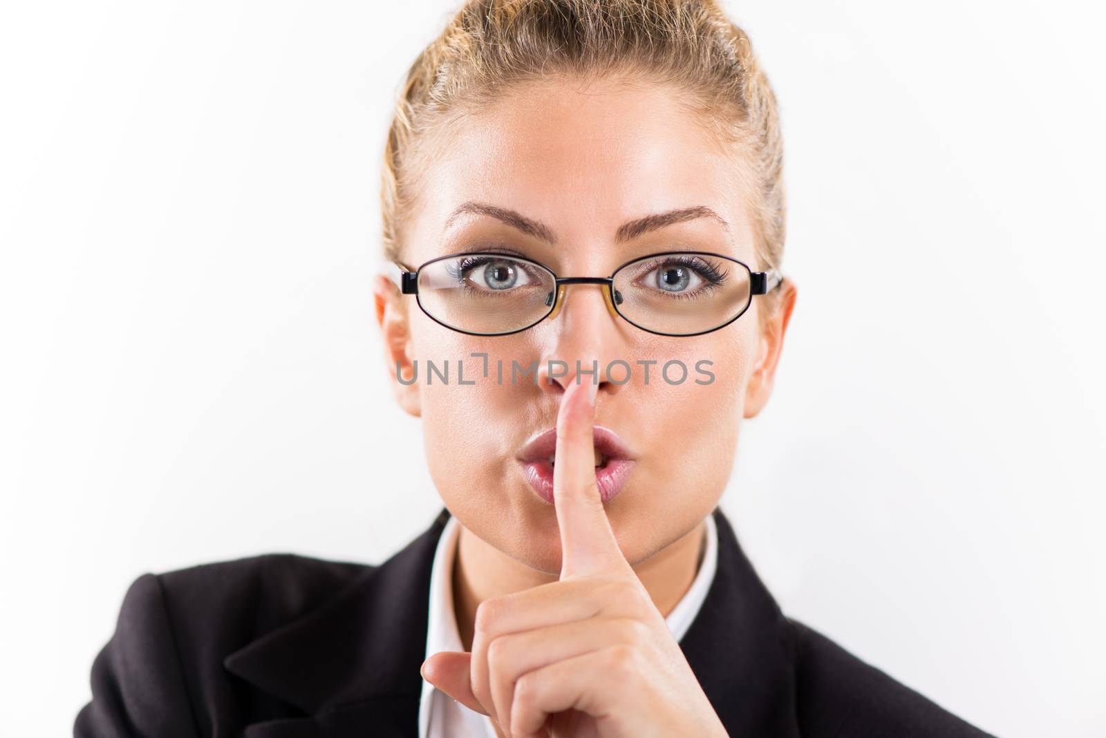 Portrait of attractive businesswoman with glasses showing shhh.