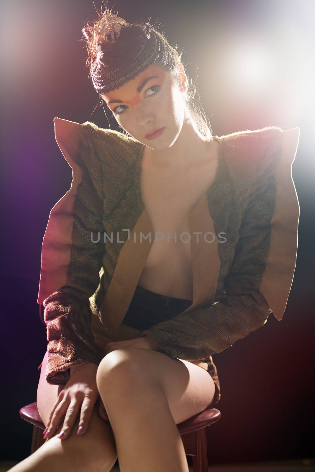 Portrait of fashion woman on a dark background illuminated by colored lights.