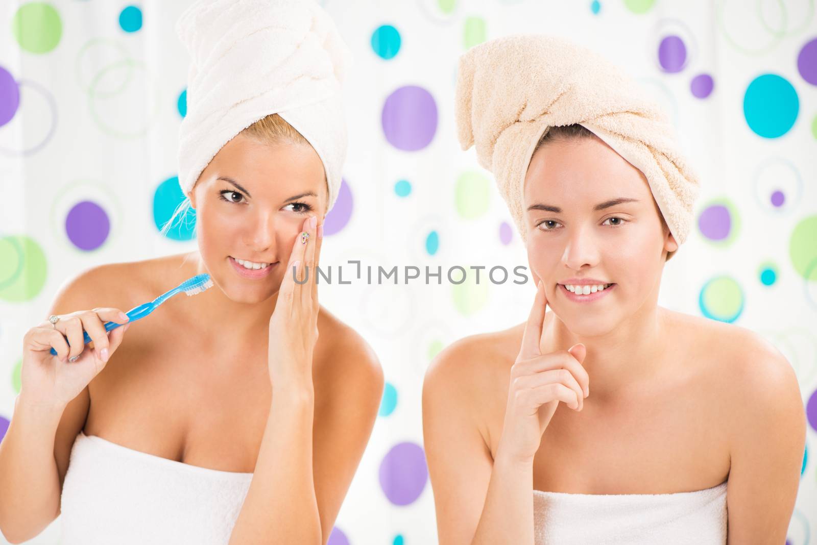 Two young woman looking at mirror and preparing to start their day.