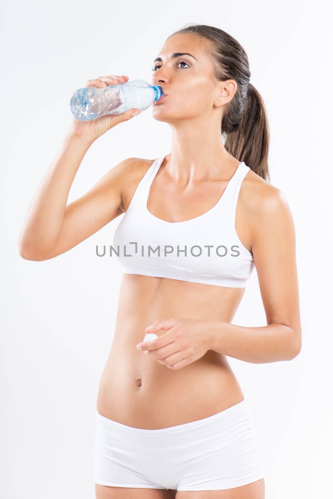 Cute young woman with underwear drinking water.