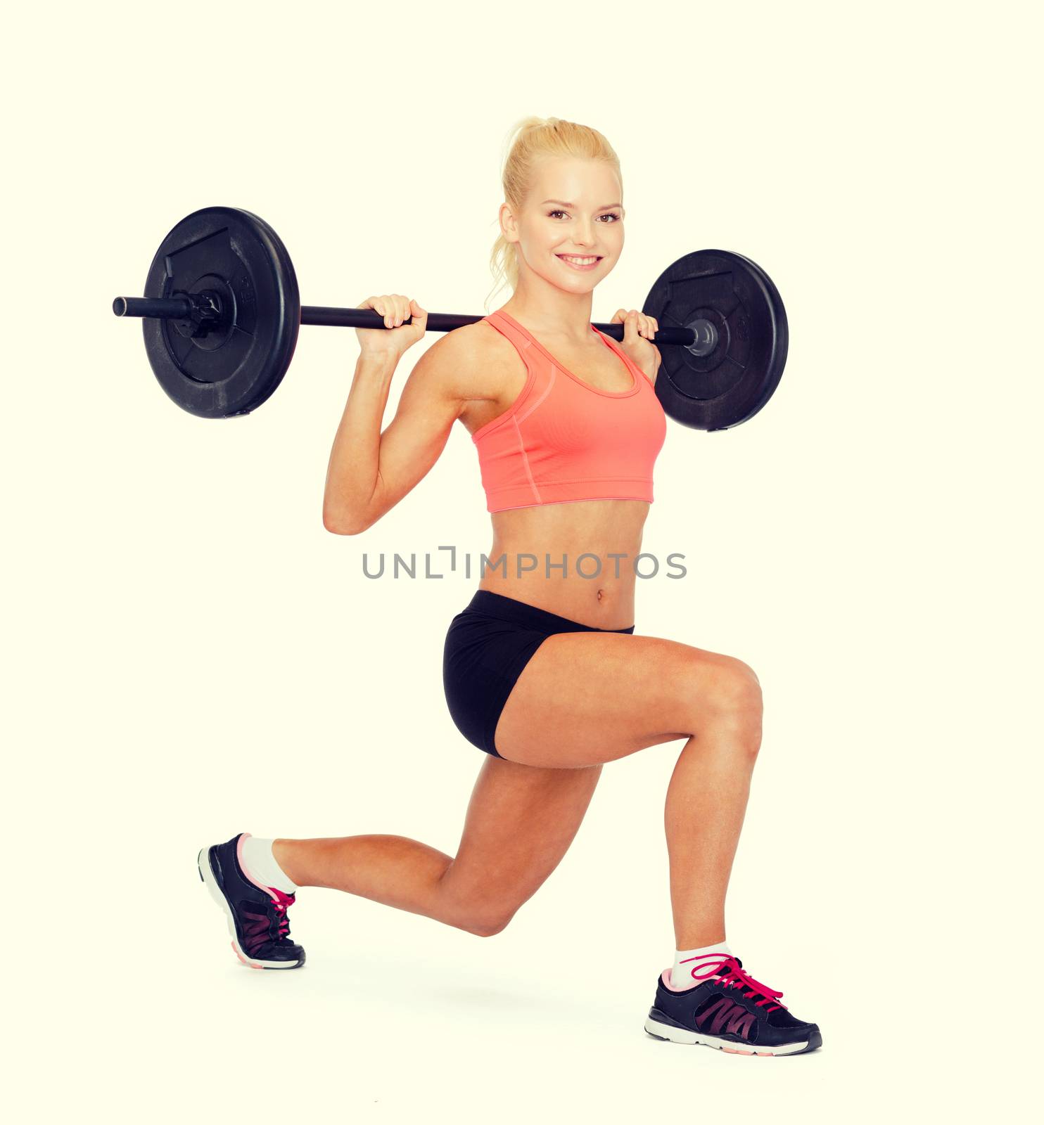 smiling sporty woman exercising with barbell by dolgachov