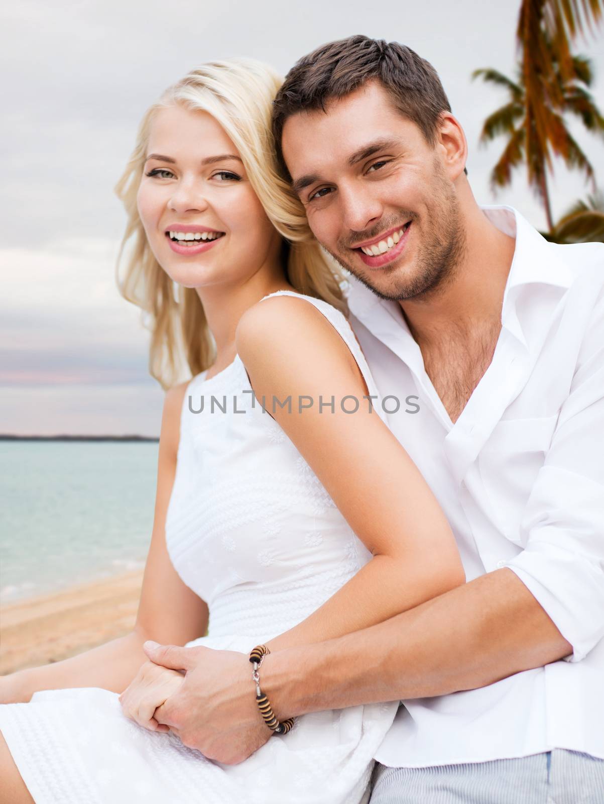 couple having fun and hugging on beach by dolgachov