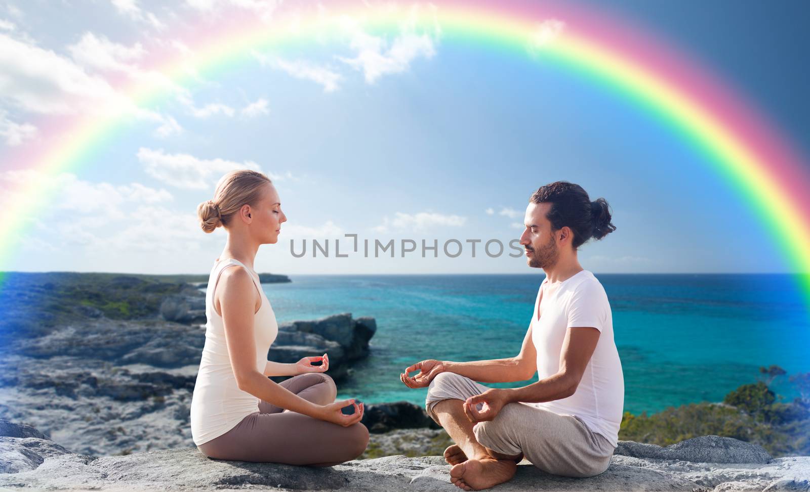 happy couple meditating in lotus pose on beach by dolgachov