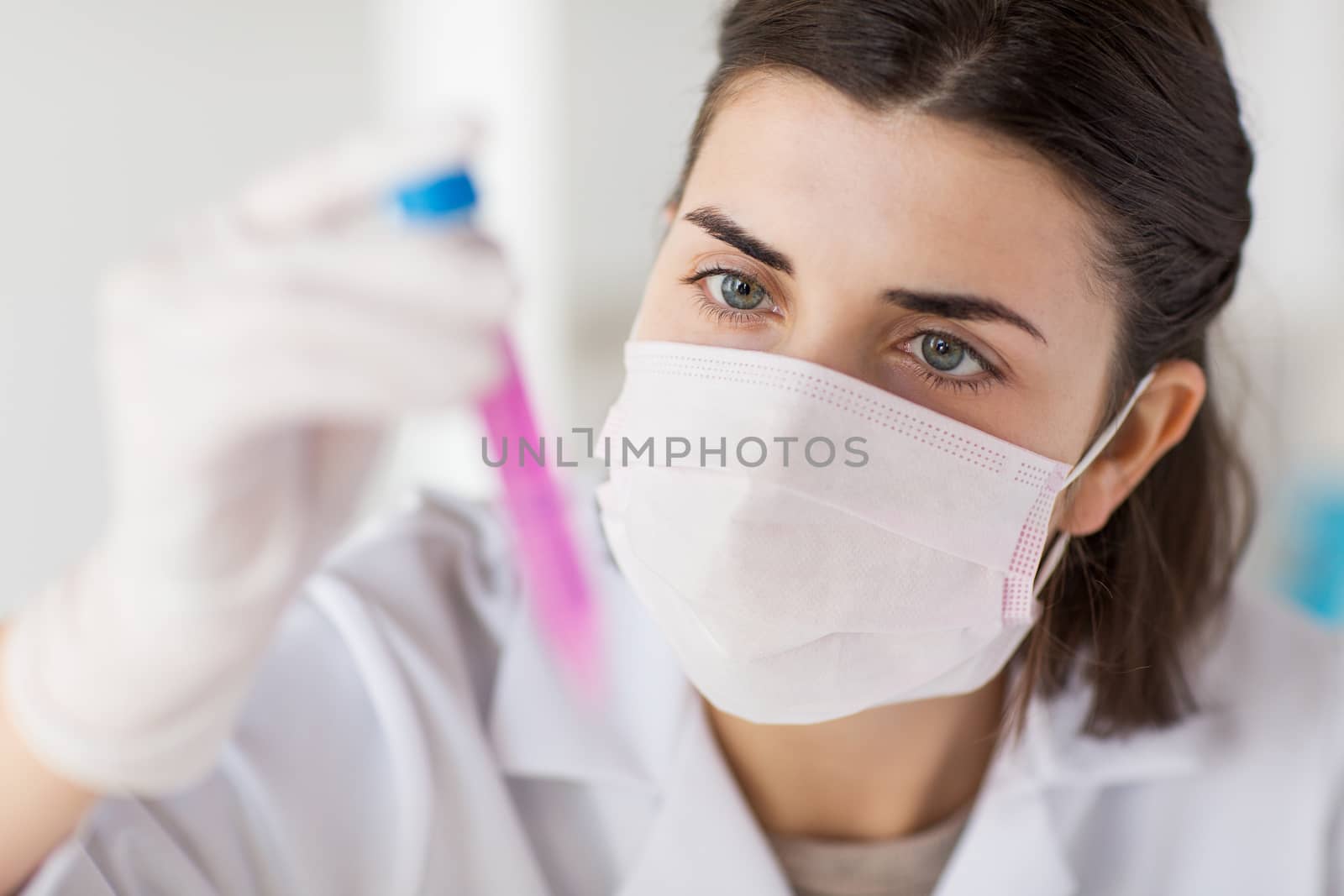 close up of scientist with tube making test in lab by dolgachov