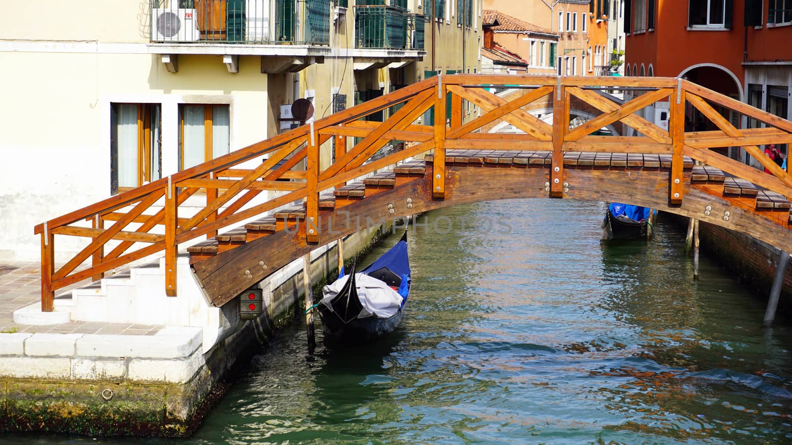 wooden bridge, canal and gondola boat in old town city Venice, Italy