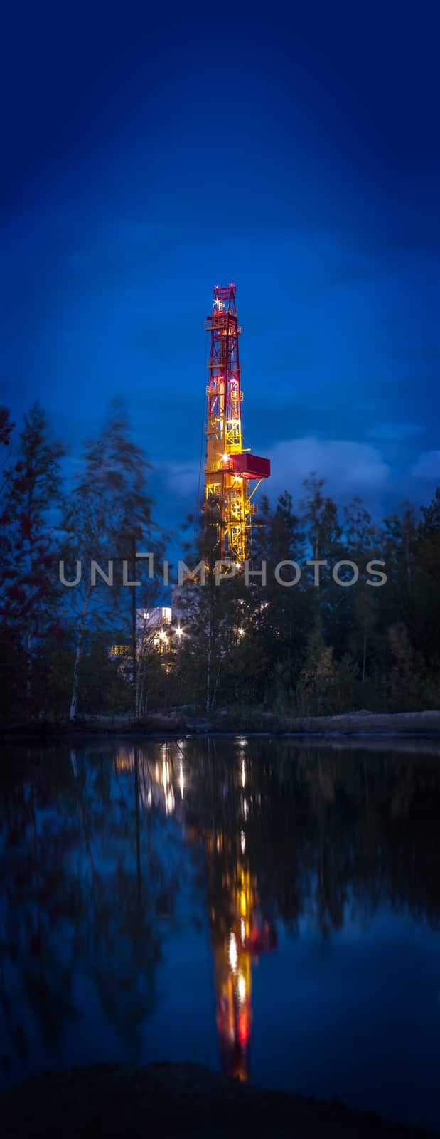 Night landscape with the drilling rig. Vertical panorama. Selective focus, shallow depth of field.