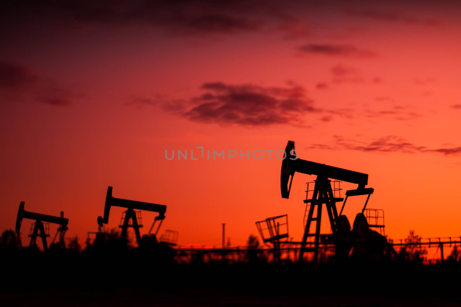 Pump Jacks at sunset sky background. Selective focus, shallow depth of field.
