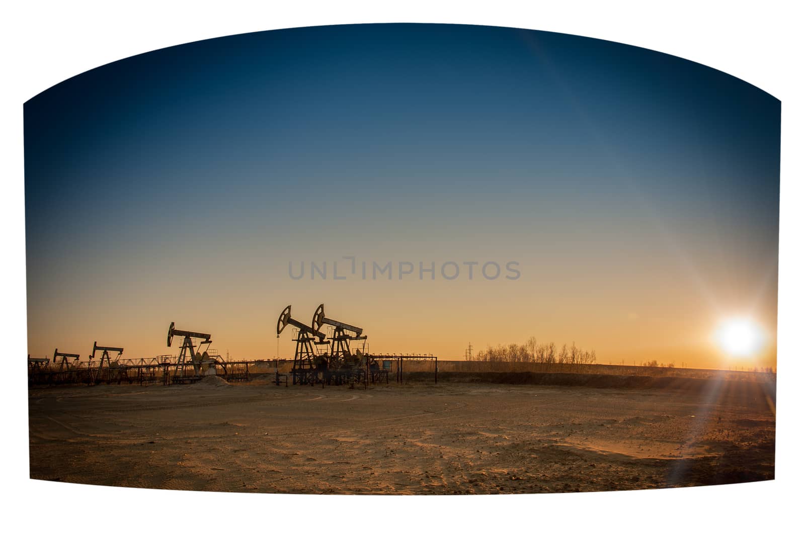 Oil pumps on the sunset sky background.