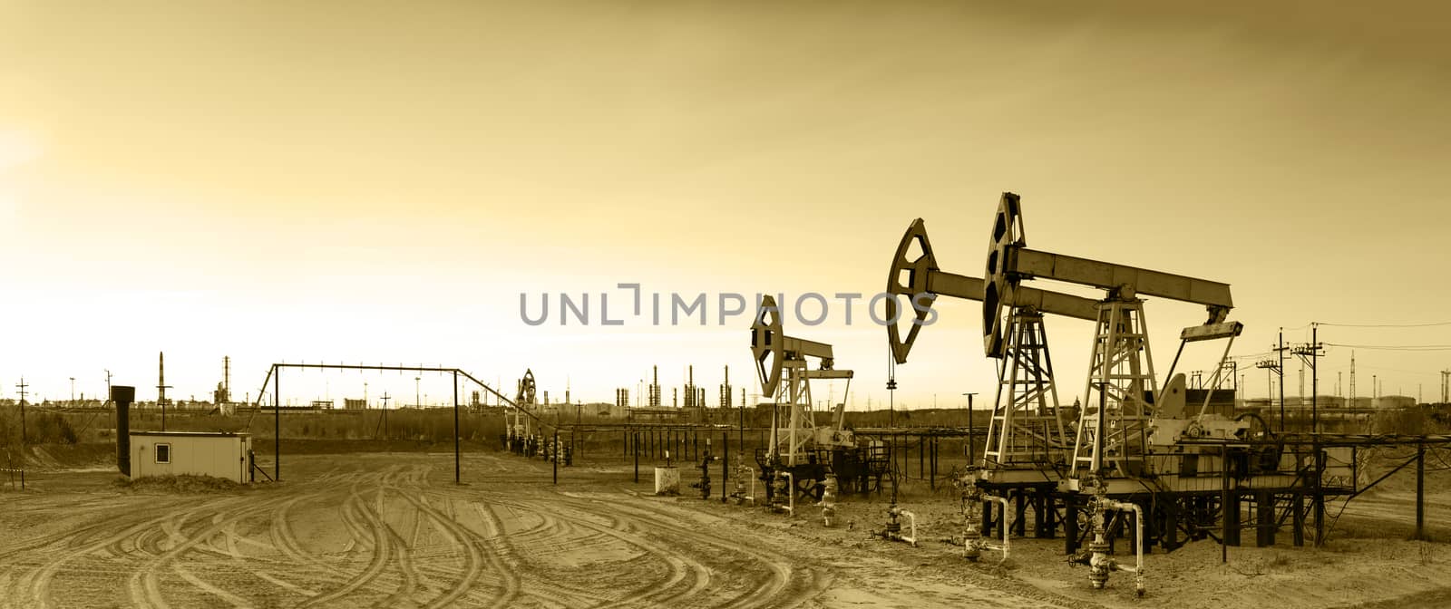 Oil and gas industry. Panoramic of a pumpjack and oil refinery. 