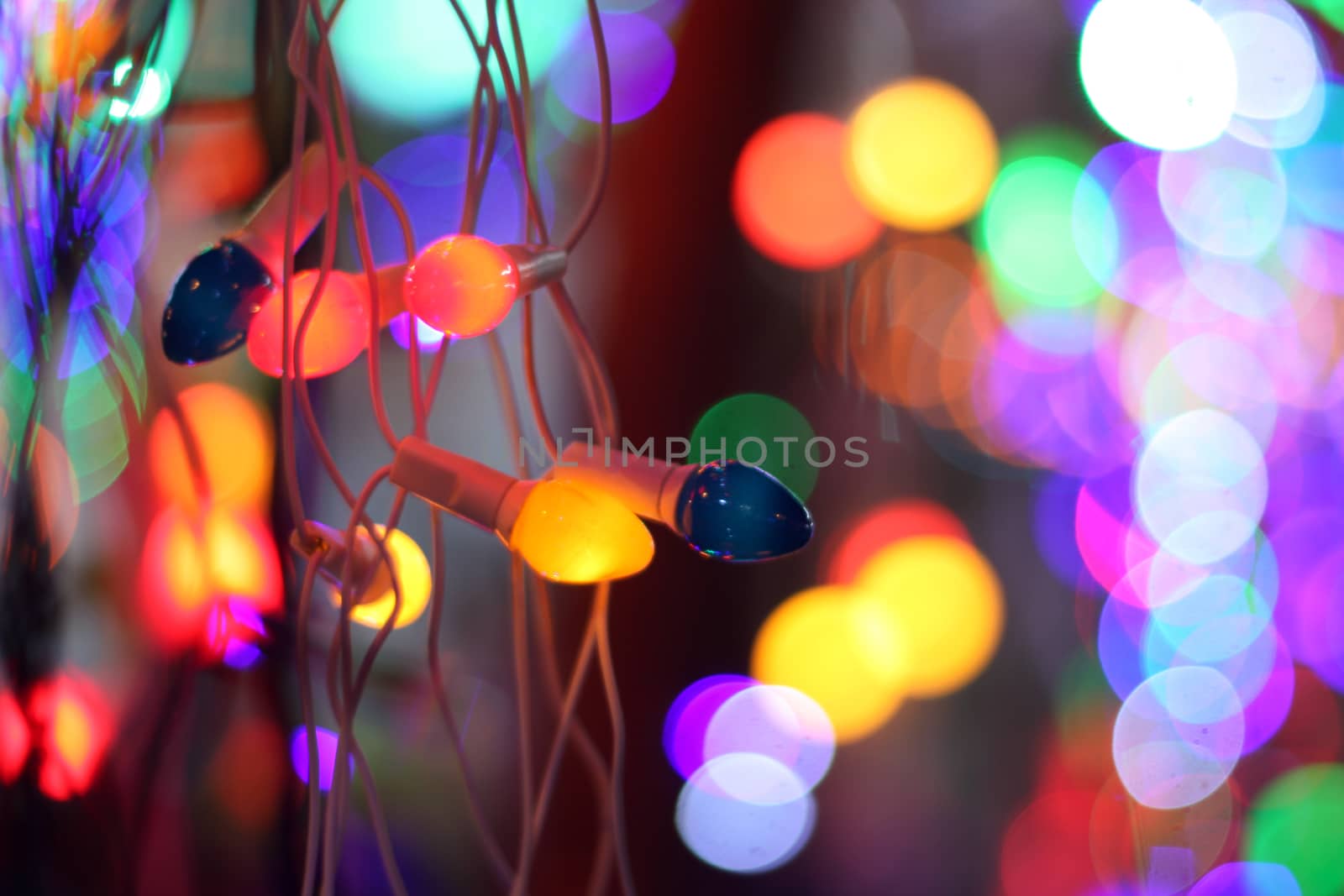 Colorful line of festive decoration lights, on the background of blurred colorful lights