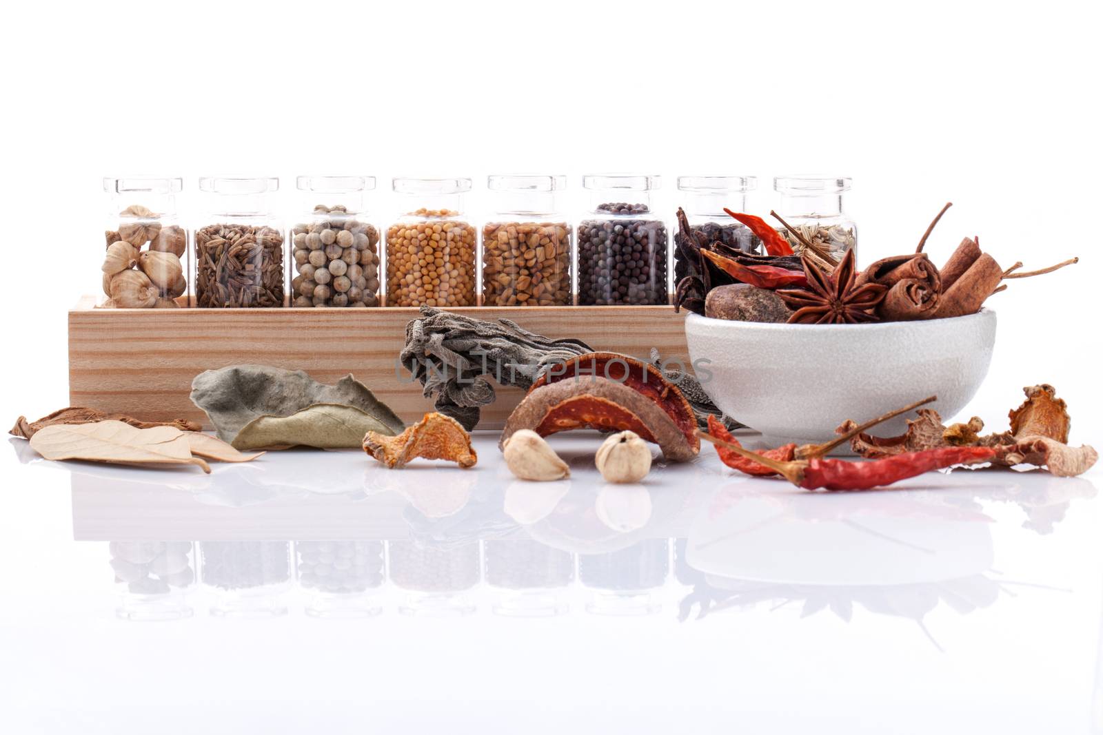 Assorted of spice bottles condiment black pepper ,white pepper, black mustard,white mustard,fenugreek,cumin ,bay leaf ,cinnamon and fennel seeds with mortar isolated on white background.