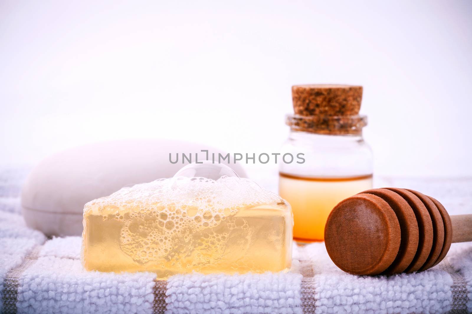 Herbal spa soap bar on white bath towel with honey isolate on white background.