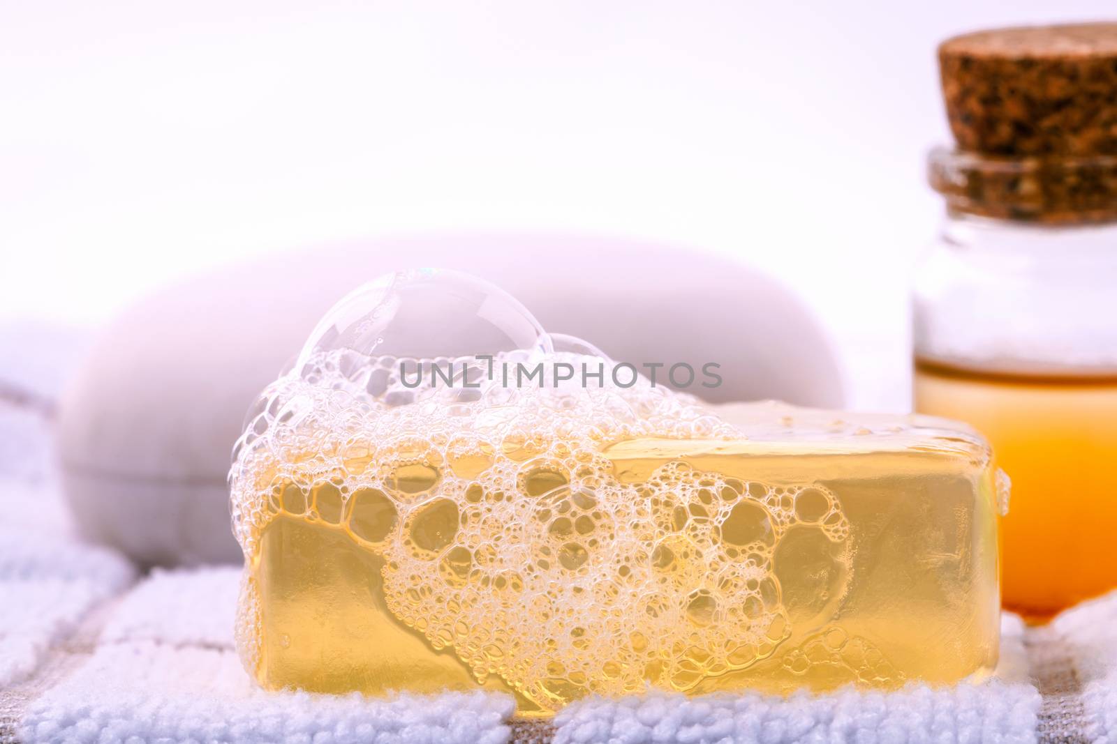 Herbal spa soap bar on white bath towel with honey isolate on white background.