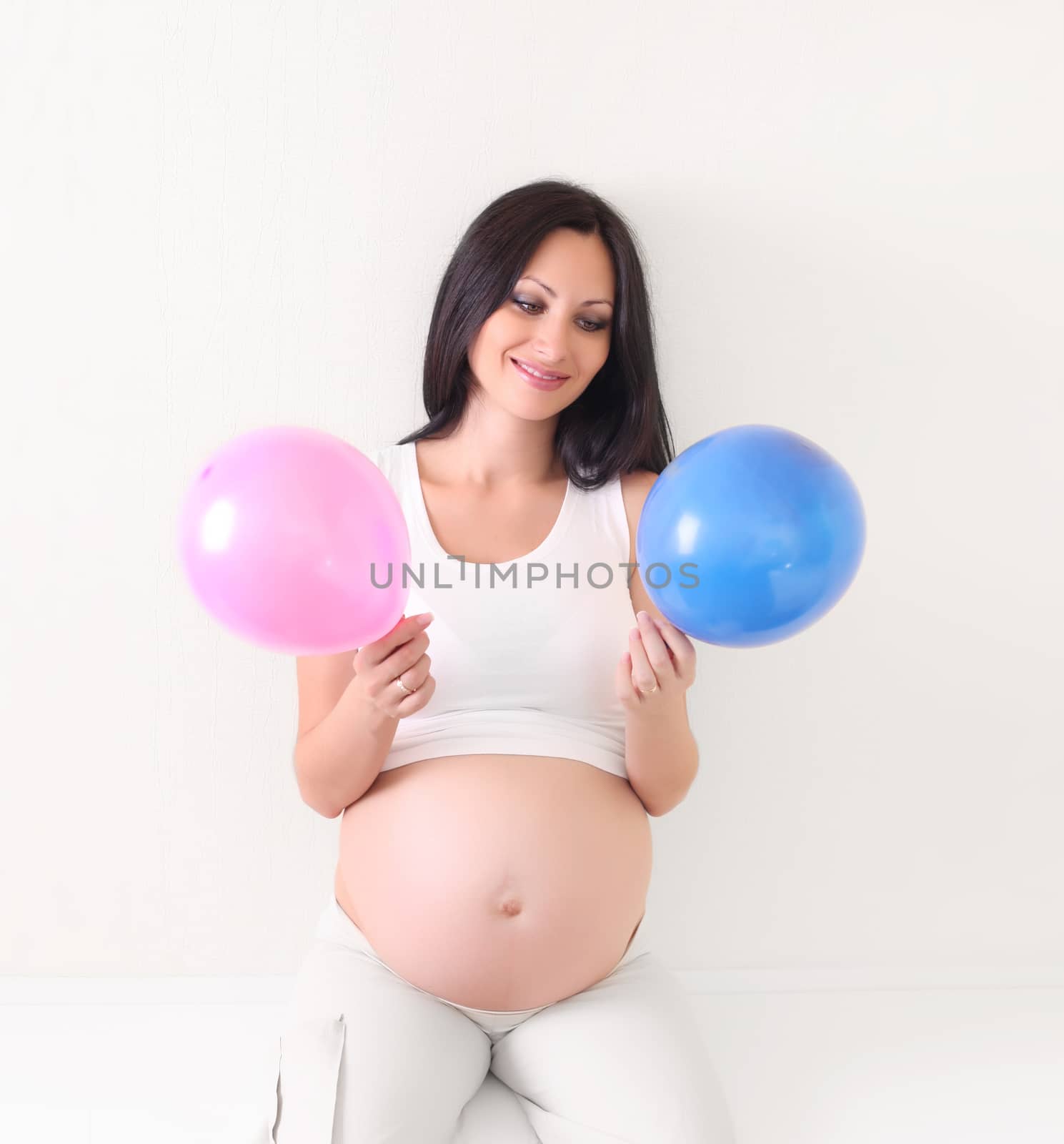 pregnant woman with blue and pink balloon by rudchenko