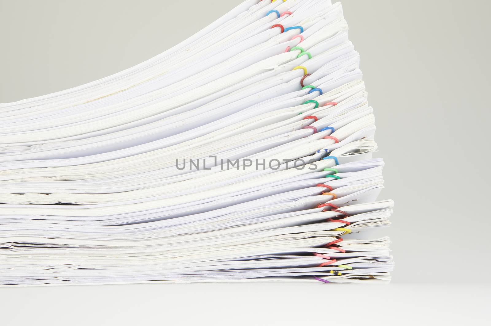 Pile of paper of report and paperwork on table near wall.