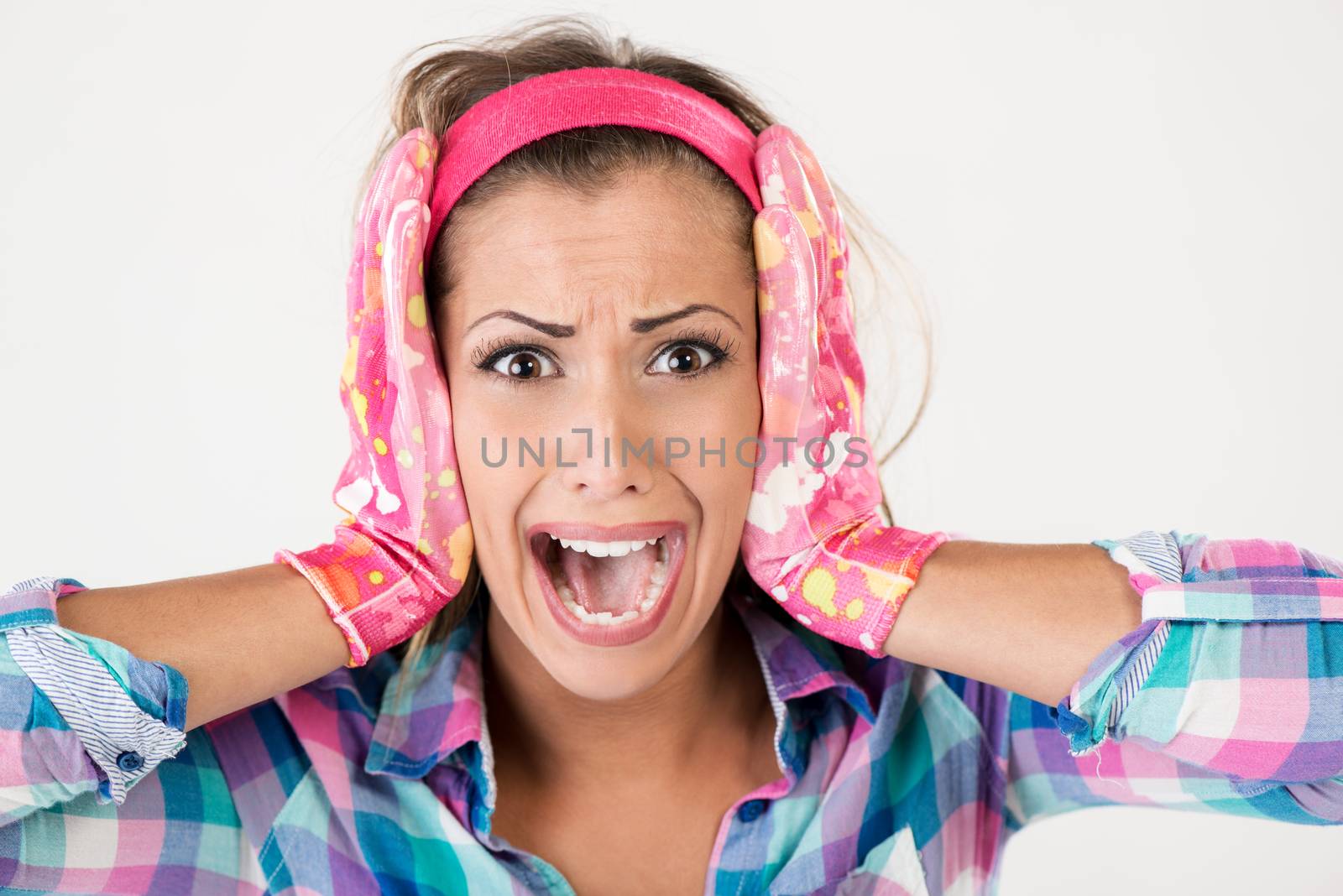 Spring cleaning woman screaming. She is stressed, wearing pink rubber gloves and looking at camera. White background.