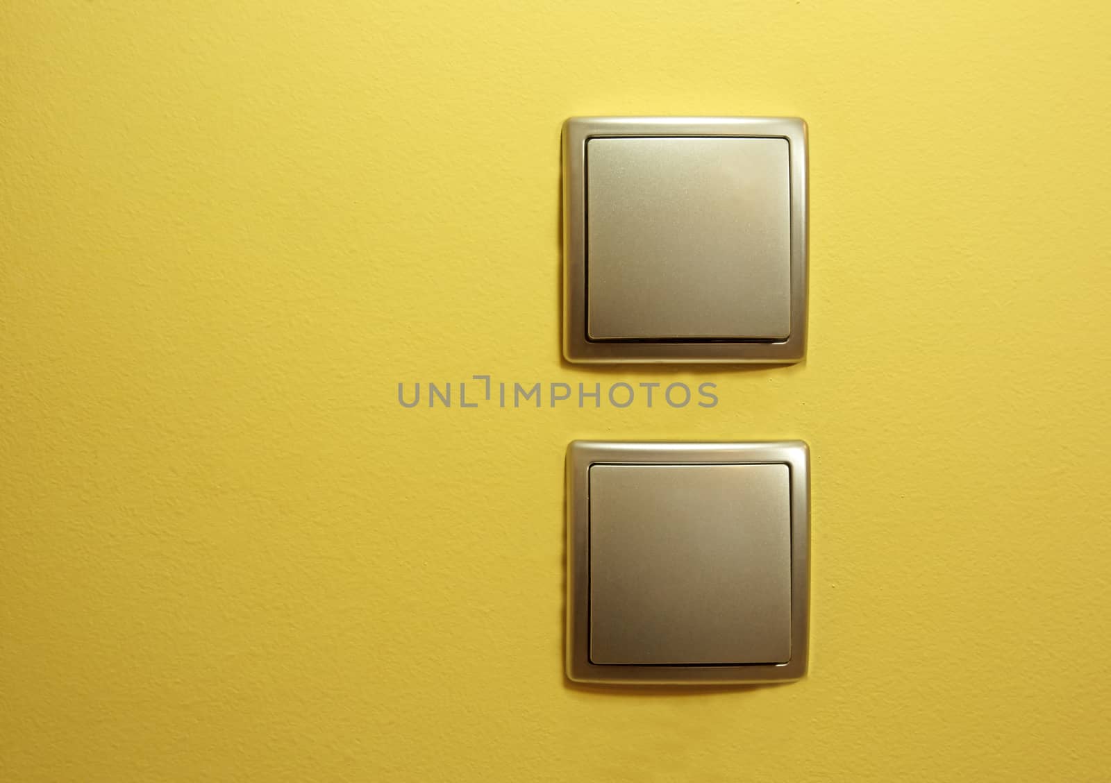 Two flat silver power switch, one below the other on the yellow  by kuba61