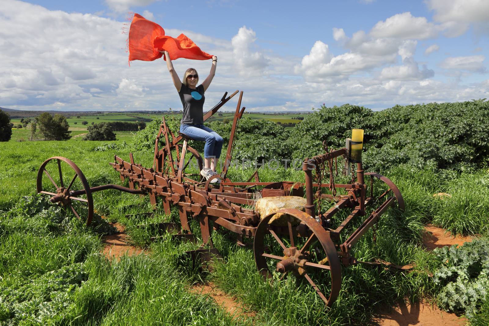 Sitting on an old rusty farm plough or till in country rural Central West  NSW Australia