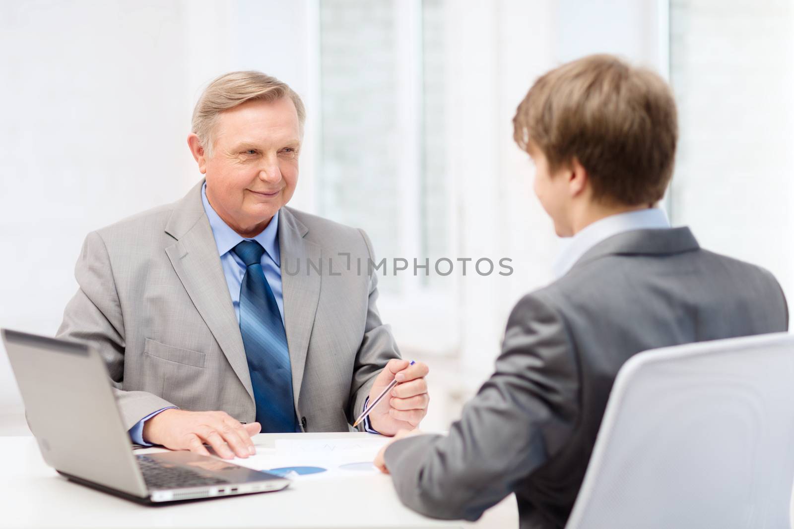 older man and young man having meeting in office by dolgachov