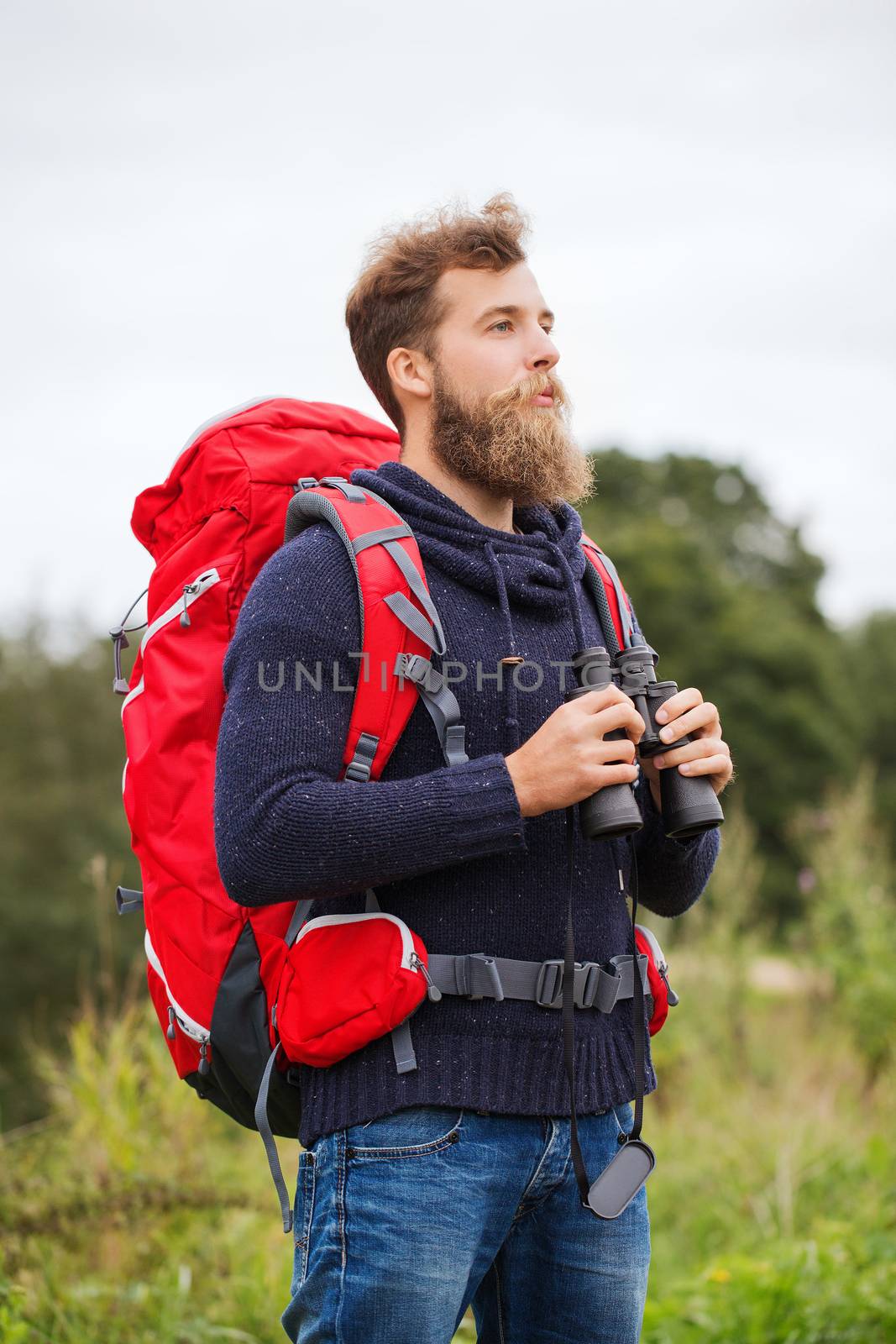 adventure, travel, tourism, hike and people concept - man with red backpack and binocular outdoors