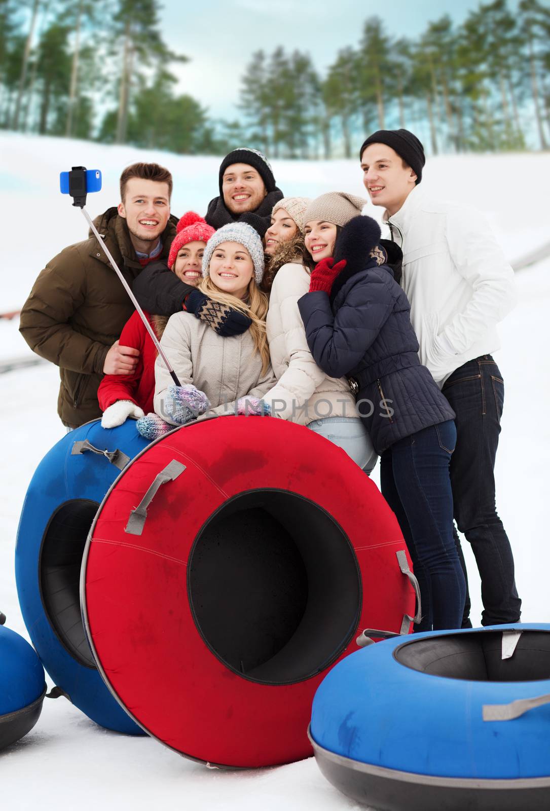 group of smiling friends with snow tubes by dolgachov