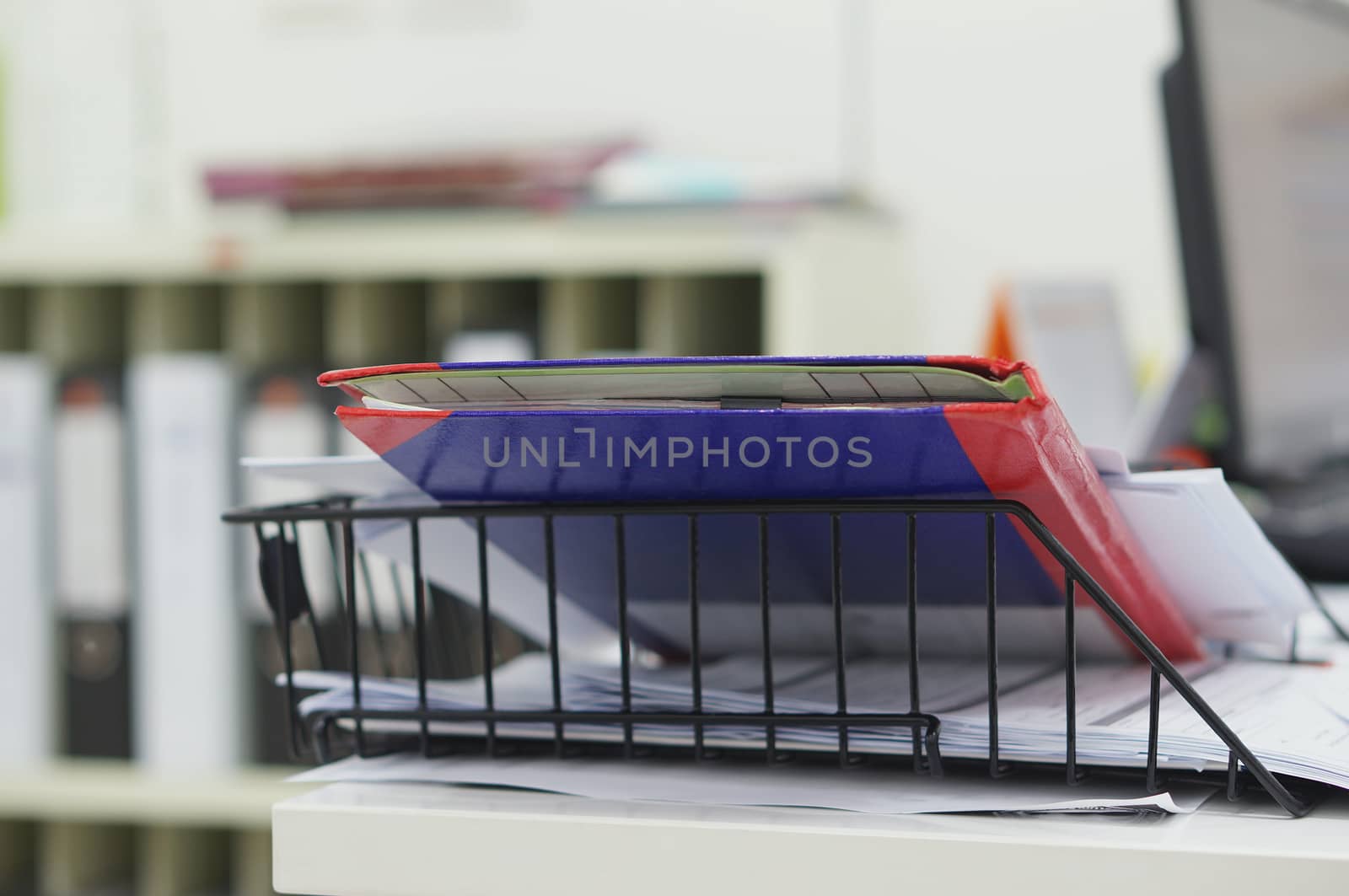 Report book and file work in black basket at office.                               