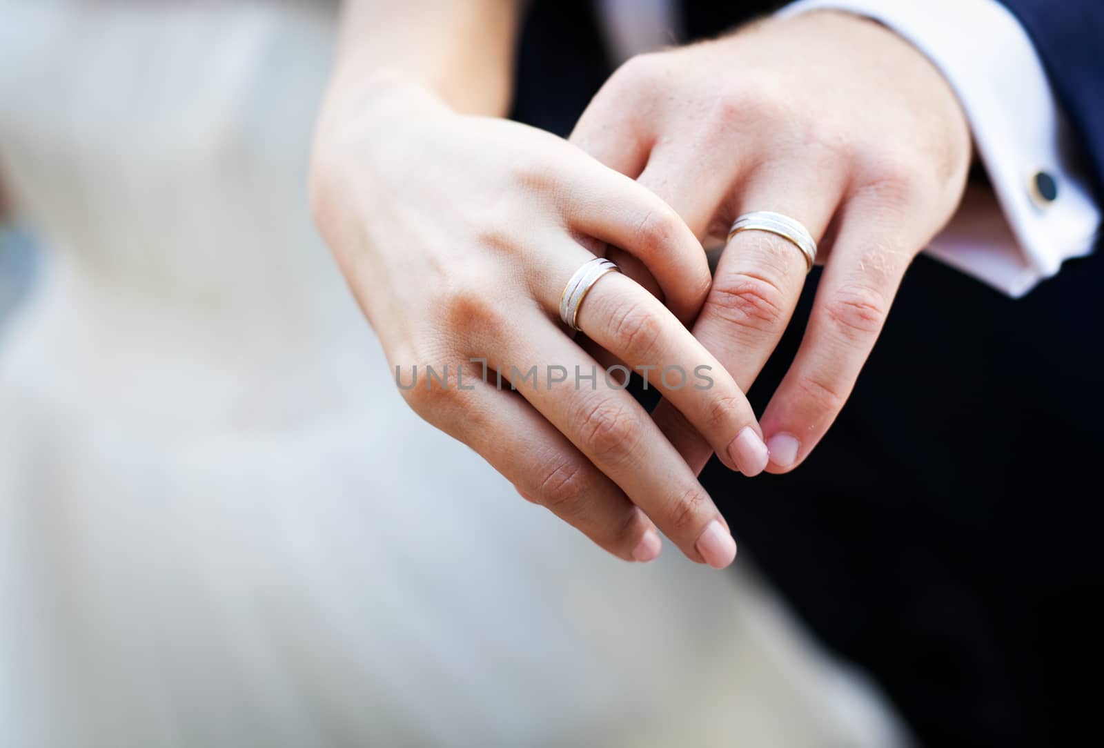 Hands and rings on wedding bouquet