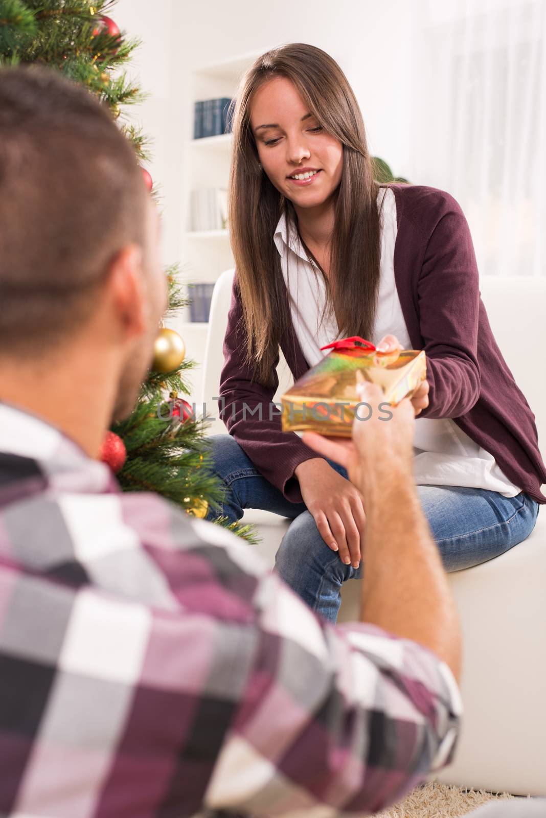 Young man gives his girlfriend a Christmas gift.