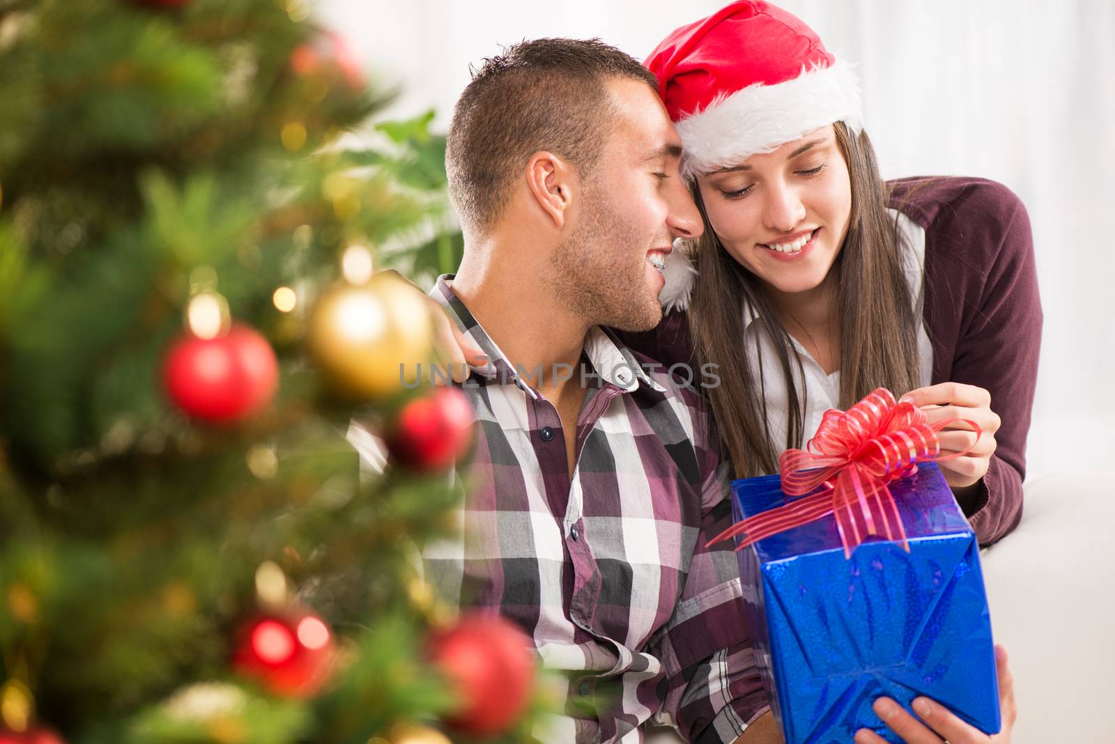 Young beautiful couple exchanging a Christmas gifts.