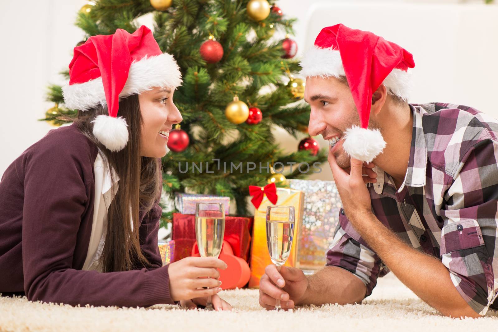 Young beautiful couple Celebrating Christmas or New Year with glass of champagne.
