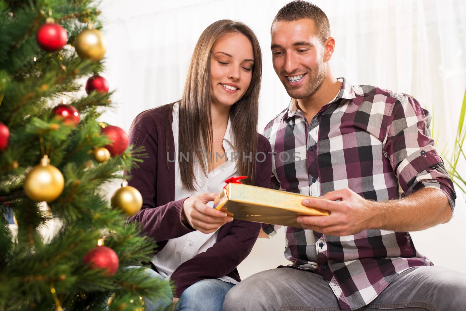 Young man gives his girlfriend a Christmas gift.