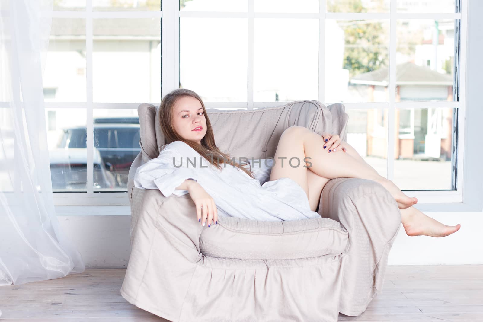 Young woman at home sitting on modern chair by victosha