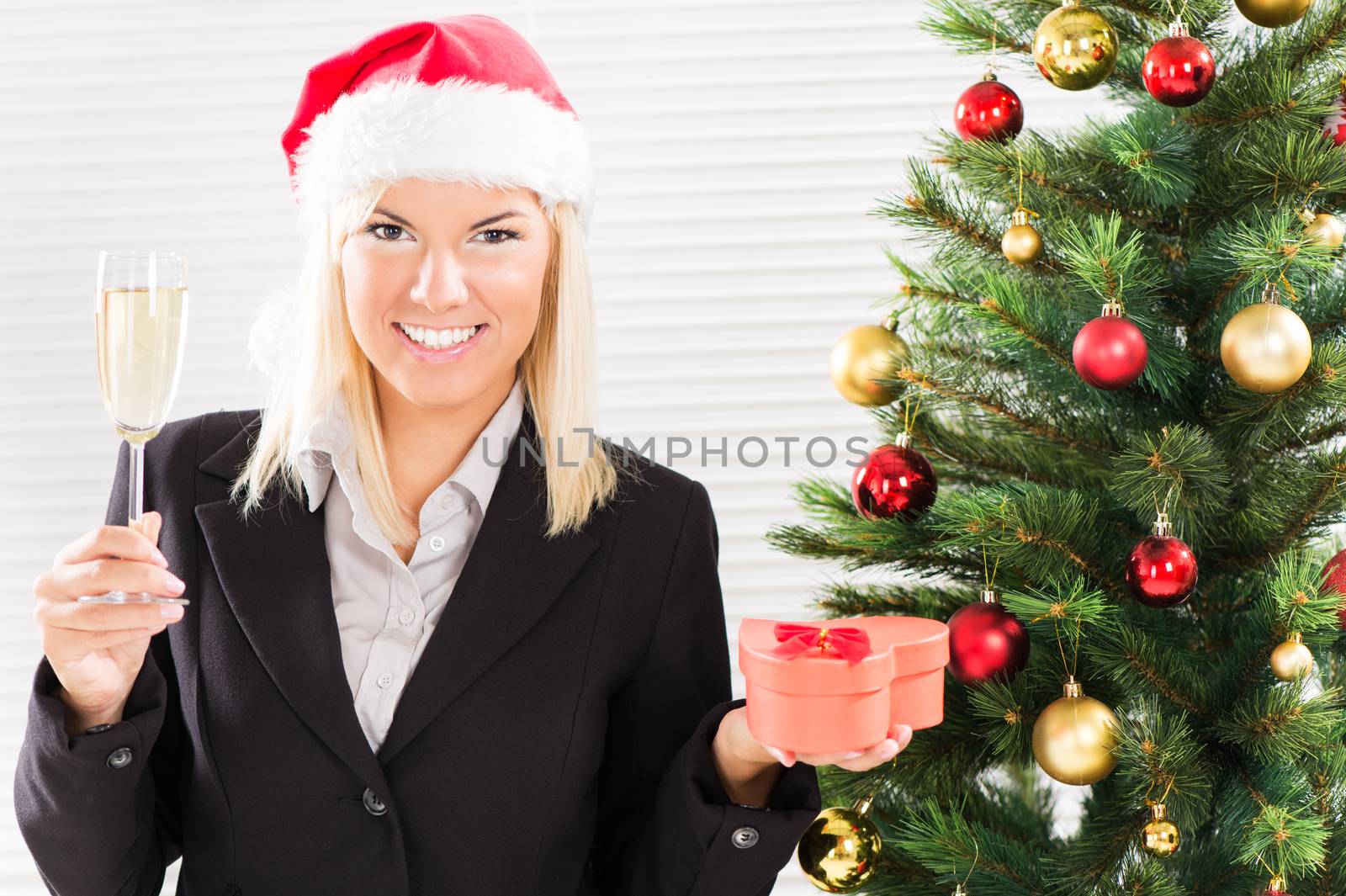 Happy Christmas businesswoman with Santa holding champagne and little gift.