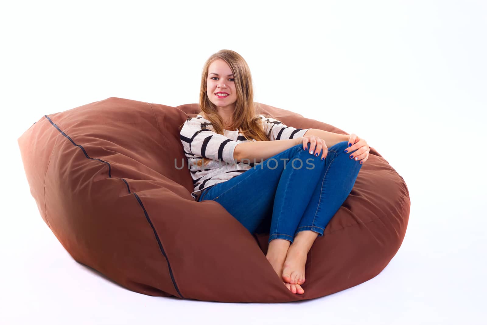 cute girl sitting on a braun beanbag chair.