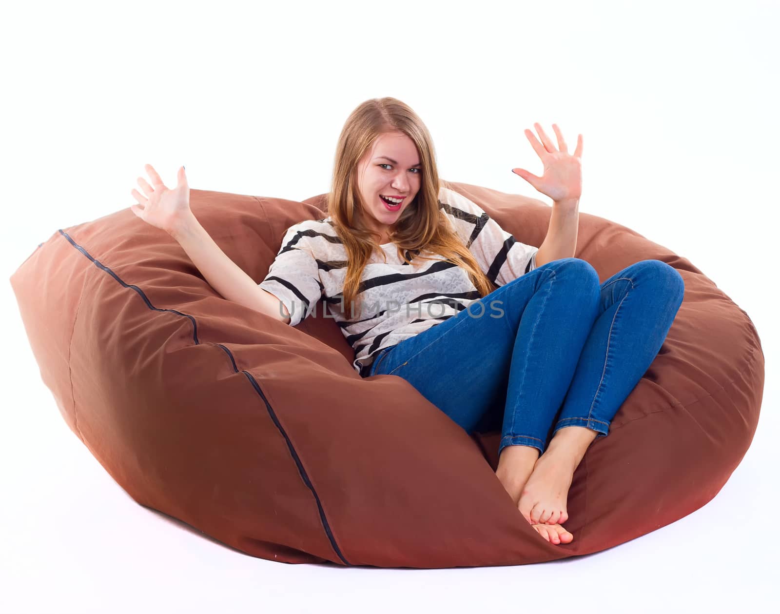 cute girl sitting on a braun beanbag chair.