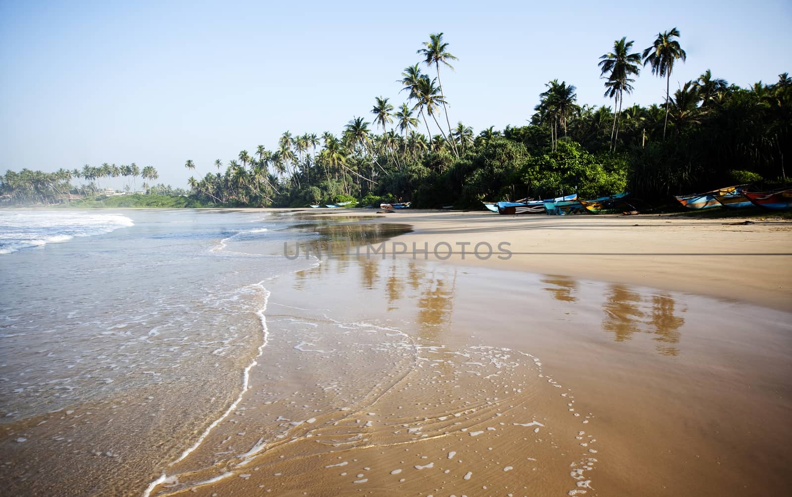 Untouched tropical beach with fishing boat in Sri Lanka